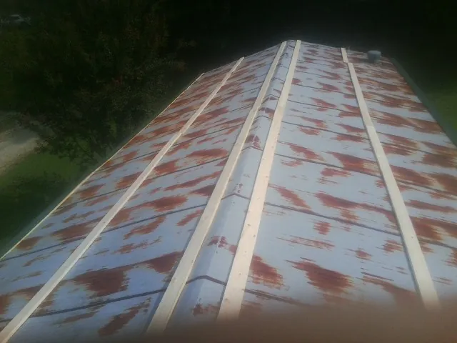 Rusted metal roof panels with new wood purlins before replacement — Storm Damage Roof Repair in Saint Matthews by Roofing Brothers