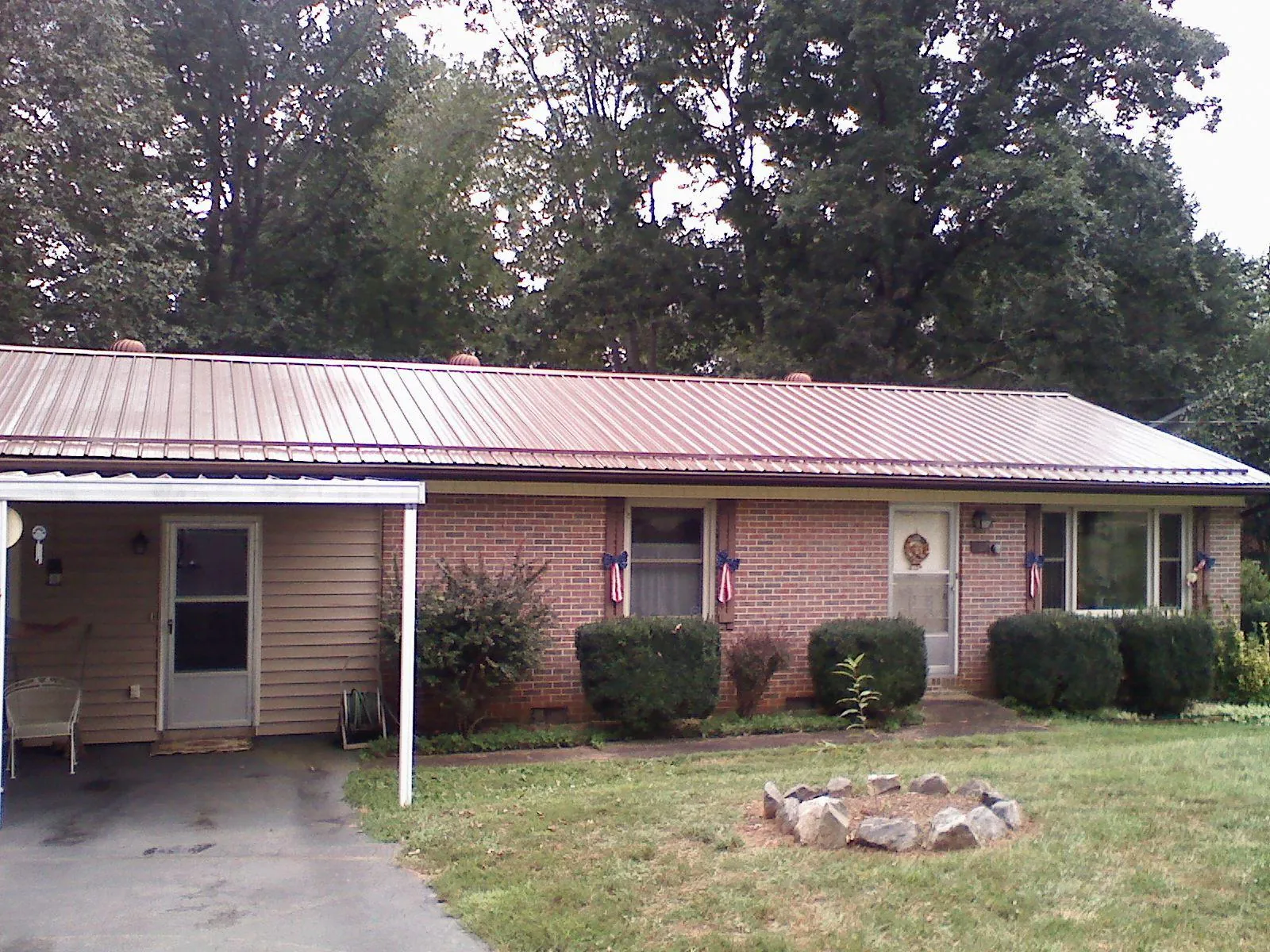 Bronze metal roof and carport on a brick ranch home — Roof Repair work by our crew in Saint Matthews